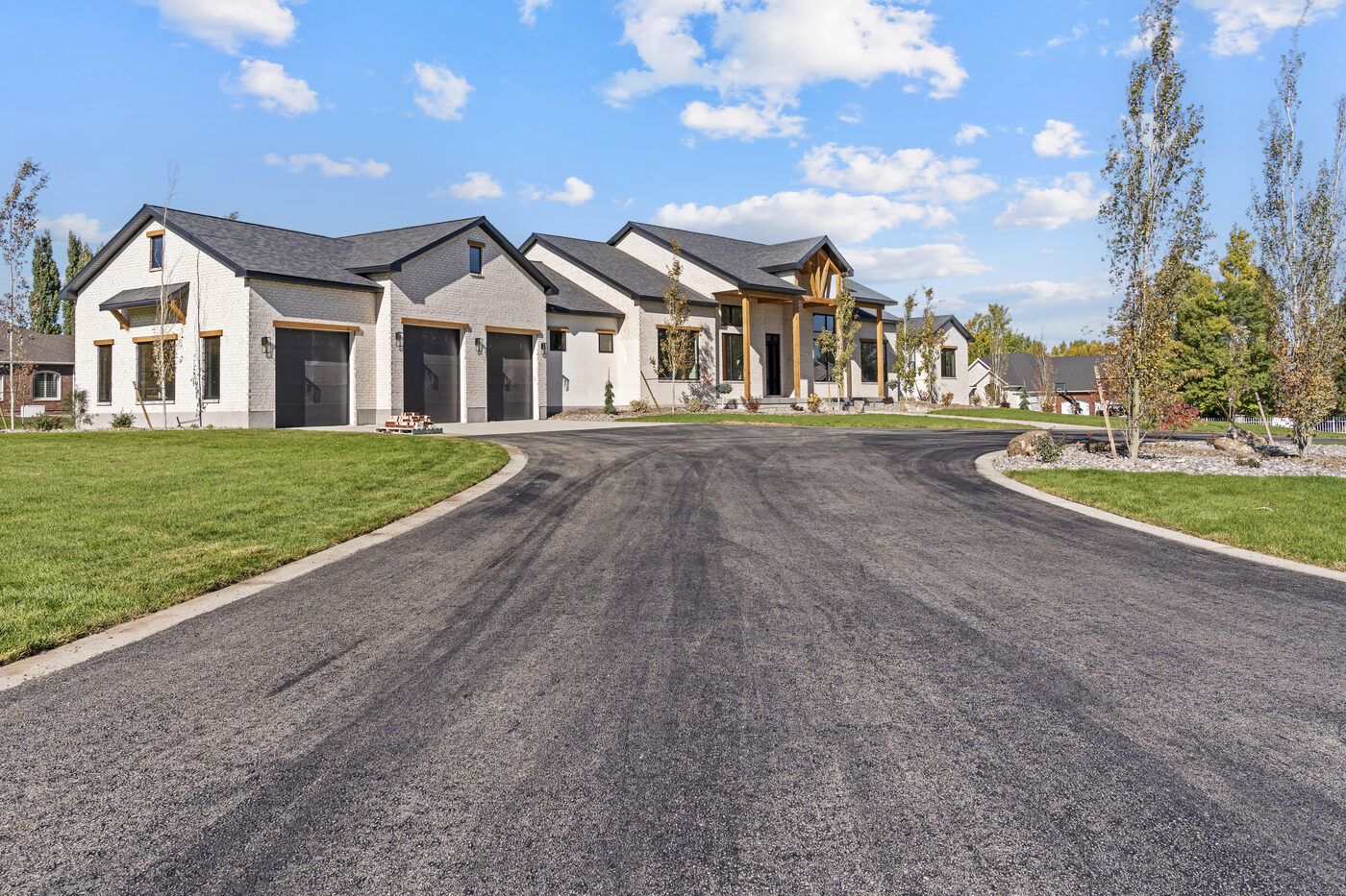 560 Partridge Lane front exterior — all-brick new construction with circular driveway in Rexburg Idaho