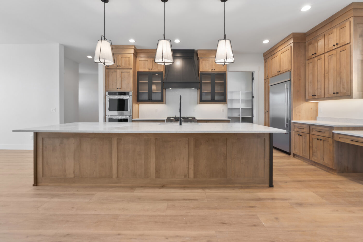 Kitchen island with pendant lighting and warm wood cabinets — 560 Partridge Lane gourmet kitchen